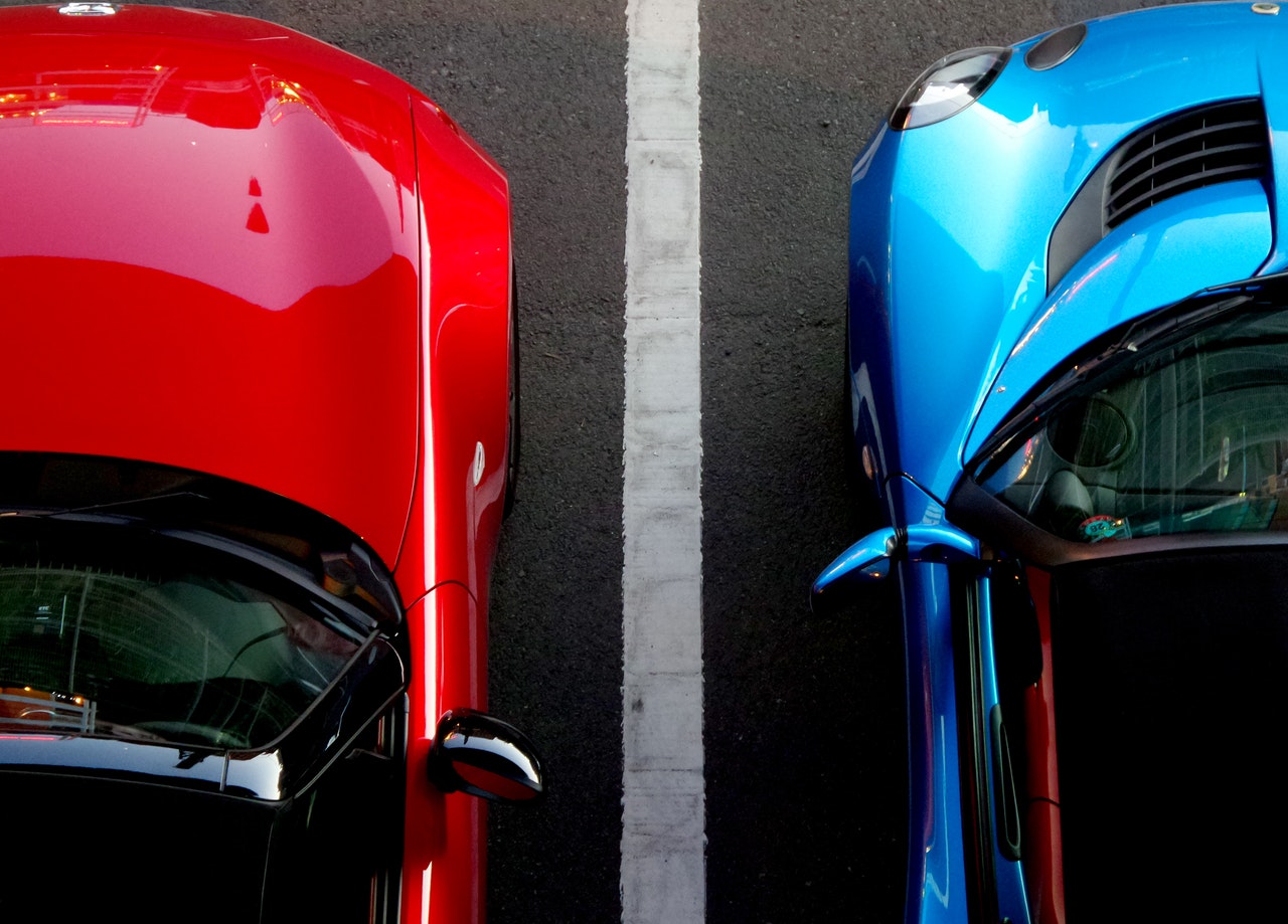 blue and red cars parked next to each other
